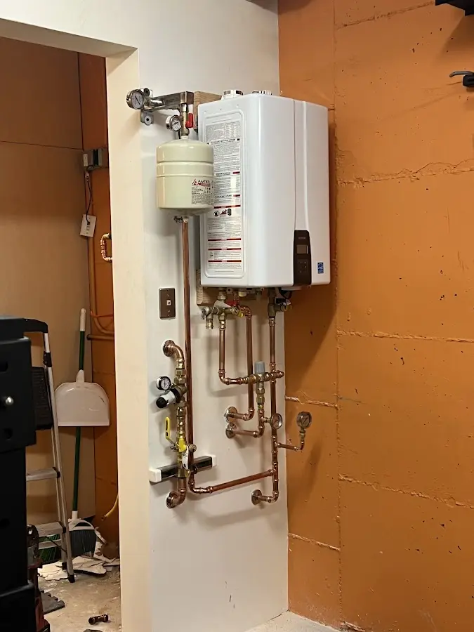 Plumbing technician inspecting water heater connections in Kenneth City